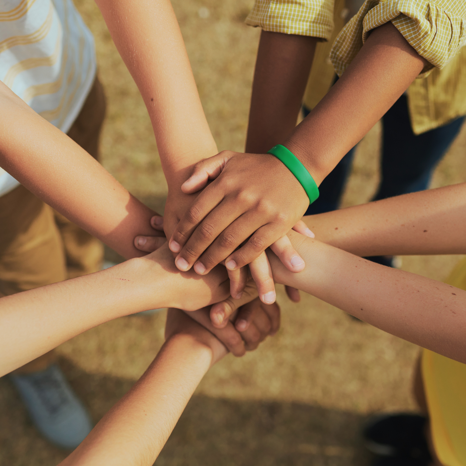 children stacking hands outdoors